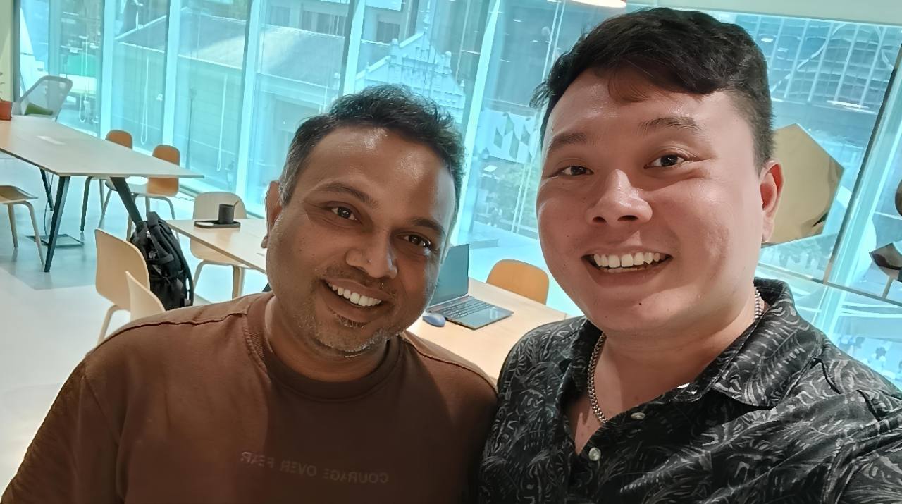 Alvin smiling with a client during an in-person office meeting.